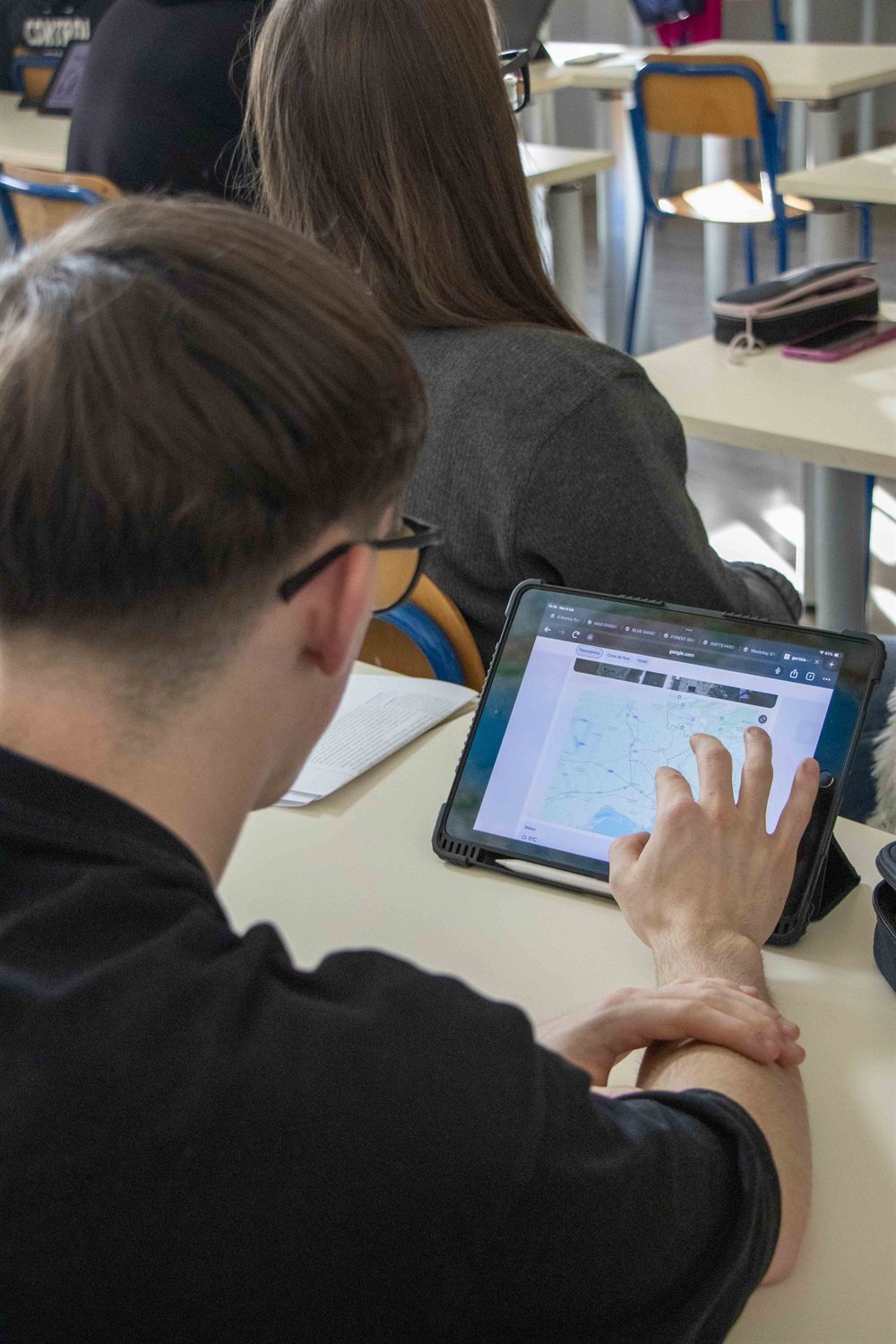 Studente che consulta una mappa su tablet in aula